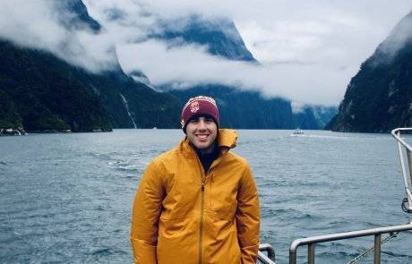 Jack Tamisiea in front of cold lake and mountains on a boat