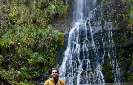 picture of Jack Tamisiea standing in front of a waterfall in what looks like a rainforest